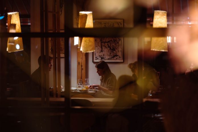 Romantic dining scene in a cozy restaurant with warm lighting and intimate atmosphere.