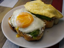 Tasty breakfast with fried egg and avocado on toast, ideal for food lovers.