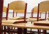 A modern and empty classroom featuring wooden chairs and desks with a focus on education and learning spaces.