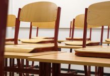A modern and empty classroom featuring wooden chairs and desks with a focus on education and learning spaces.
