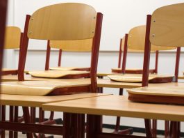 A modern and empty classroom featuring wooden chairs and desks with a focus on education and learning spaces.