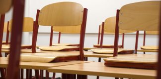 A modern and empty classroom featuring wooden chairs and desks with a focus on education and learning spaces.