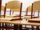 A modern and empty classroom featuring wooden chairs and desks with a focus on education and learning spaces.