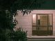 Your Guide to Funeral Homes in Jersey City A serene nighttime view of a modern building entrance with surrounding foliage, creating a warm and inviting atmosphere.
