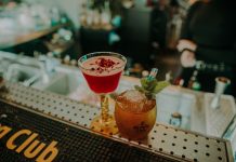 Two vibrant cocktails on a bar counter showcasing a sophisticated nightlife atmosphere.
