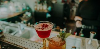 Two vibrant cocktails on a bar counter showcasing a sophisticated nightlife atmosphere.