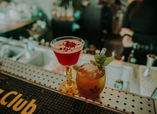Two vibrant cocktails on a bar counter showcasing a sophisticated nightlife atmosphere.