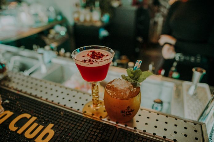Two vibrant cocktails on a bar counter showcasing a sophisticated nightlife atmosphere.