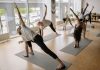A diverse group of adults engaged in yoga poses during an indoor class, emphasizing fitness and wellness.