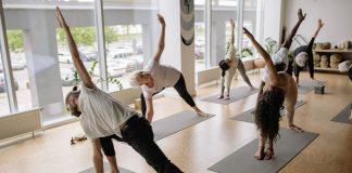 A diverse group of adults engaged in yoga poses during an indoor class, emphasizing fitness and wellness.