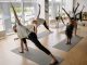 Your Summer Wellness Guide: Hudson County Deals & Spots A diverse group of adults engaged in yoga poses during an indoor class, emphasizing fitness and wellness.