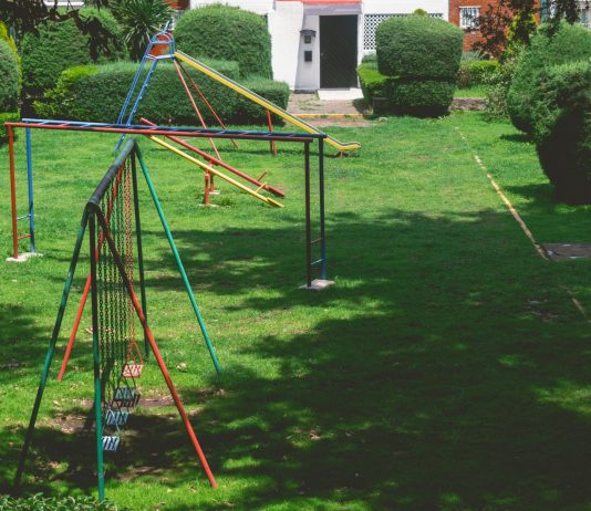 Actividades para Niños en Union City: 15 Planes Divertidos para 2026 Vibrant outdoor playground with swings and slides in a lush green park setting under a bright sky.