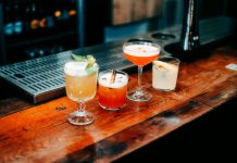 A vibrant selection of cocktails on a wooden bar, perfect for nightlife and parties.