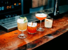 A vibrant selection of cocktails on a wooden bar, perfect for nightlife and parties.