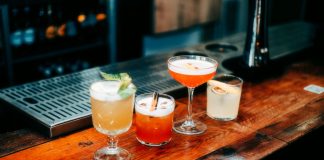 A vibrant selection of cocktails on a wooden bar, perfect for nightlife and parties.