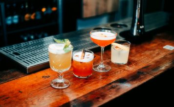 Best Bars in Newark for a Night Out in 2026: Your Local Guide A vibrant selection of cocktails on a wooden bar, perfect for nightlife and parties.