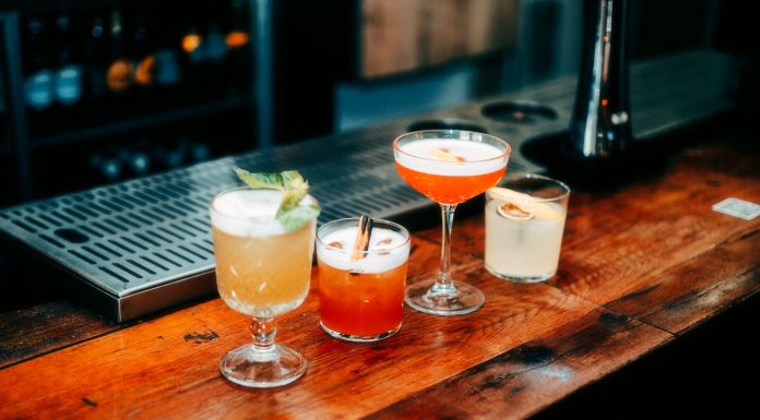 A vibrant selection of cocktails on a wooden bar, perfect for nightlife and parties.