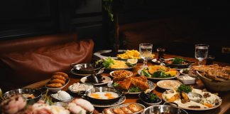 A lavish breakfast spread featuring various dishes elegantly set on a rustic wooden table.