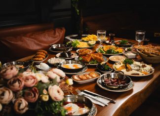 A lavish breakfast spread featuring various dishes elegantly set on a rustic wooden table.
