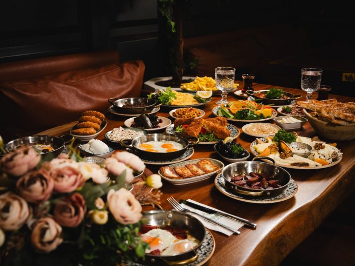 A lavish breakfast spread featuring various dishes elegantly set on a rustic wooden table.