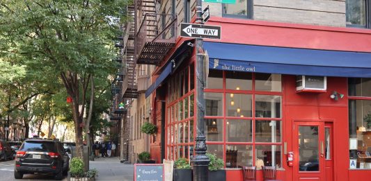 Best Breakfast Spots in West New York, NJ (2026 Local’s Guide) Cozy corner cafe and city street scene in New York with vibrant red facade and sidewalk seating.