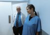 Doctors and nurses interacting in a hospital hallway, showcasing teamwork and professionalism.