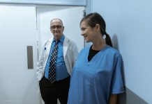 Doctors and nurses interacting in a hospital hallway, showcasing teamwork and professionalism.