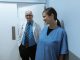 Doctors and nurses interacting in a hospital hallway, showcasing teamwork and professionalism.