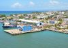 Aerial view of Puerto Plata harbor with blue buildings, ships, and a coastal town in the Dominican Republic.