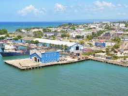 Aerial view of Puerto Plata harbor with blue buildings, ships, and a coastal town in the Dominican Republic.