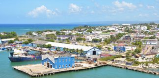 Aerial view of Puerto Plata harbor with blue buildings, ships, and a coastal town in the Dominican Republic.