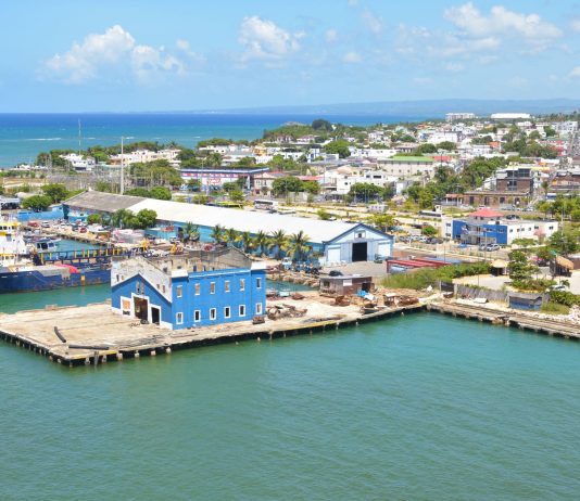 Aerial view of Puerto Plata harbor with blue buildings, ships, and a coastal town in the Dominican Republic.