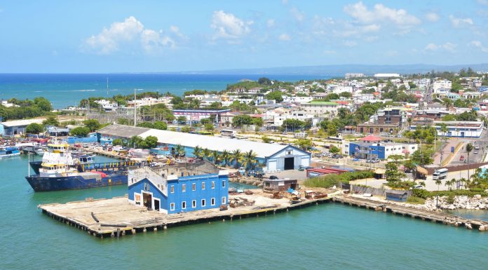 Aerial view of Puerto Plata harbor with blue buildings, ships, and a coastal town in the Dominican Republic.