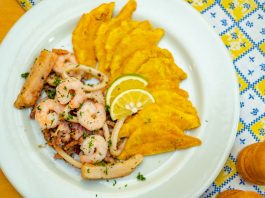 A vibrant plate of seafood and crispy plantains garnished with lemon slices, ready to savor.