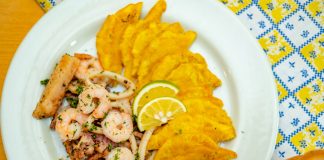 A vibrant plate of seafood and crispy plantains garnished with lemon slices, ready to savor.