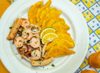 A vibrant plate of seafood and crispy plantains garnished with lemon slices, ready to savor.