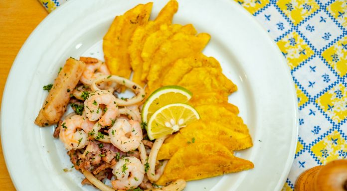 Best Dominican Restaurants in West New York, NJ (2026 Guide) A vibrant plate of seafood and crispy plantains garnished with lemon slices, ready to savor.