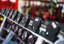 Close-up view of dumbbells in a modern gym setting, emphasizing fitness and training.