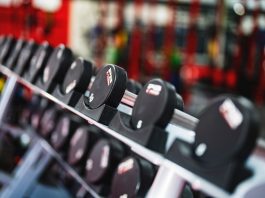 Close-up view of dumbbells in a modern gym setting, emphasizing fitness and training.