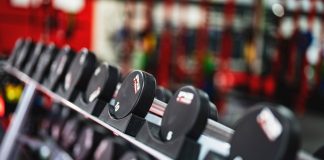 Close-up view of dumbbells in a modern gym setting, emphasizing fitness and training.