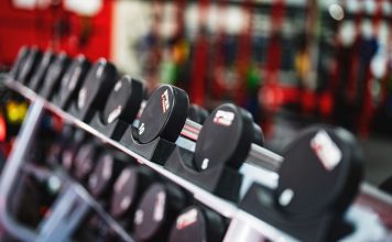 Close-up view of dumbbells in a modern gym setting, emphasizing fitness and training.