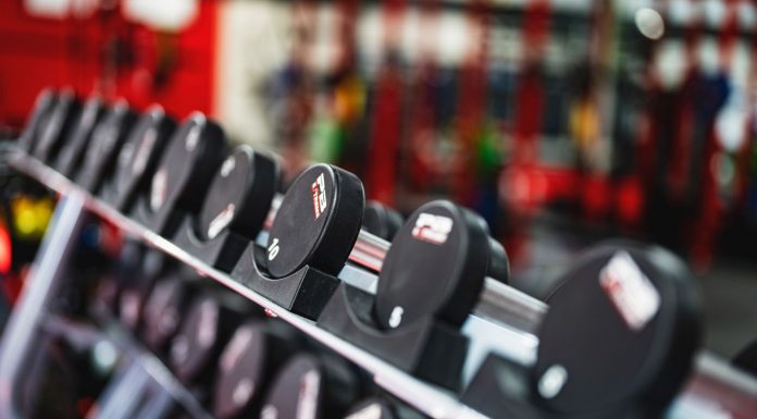 Close-up view of dumbbells in a modern gym setting, emphasizing fitness and training.