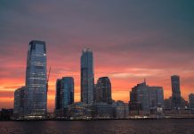 Stunning view of New York City skyline with a vibrant sunset reflecting on skyscrapers.