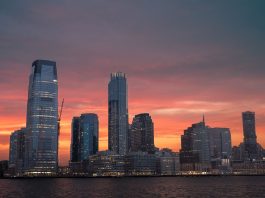 Stunning view of New York City skyline with a vibrant sunset reflecting on skyscrapers.