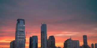 Stunning view of New York City skyline with a vibrant sunset reflecting on skyscrapers.