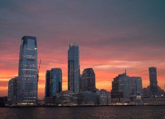 Best Neighborhoods to Live in Newark (2026 Guide) Stunning view of New York City skyline with a vibrant sunset reflecting on skyscrapers.