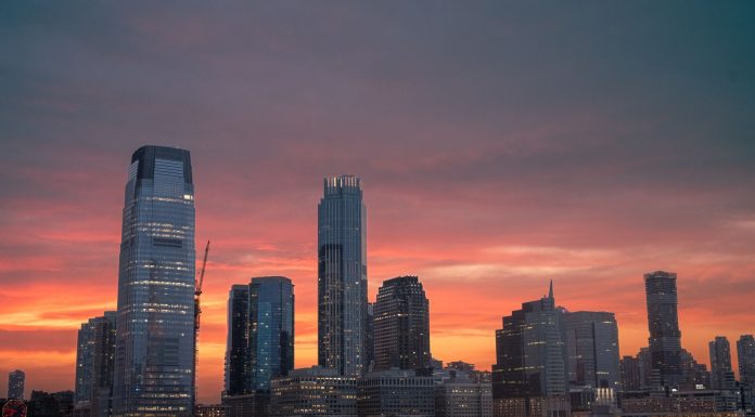 Stunning view of New York City skyline with a vibrant sunset reflecting on skyscrapers.