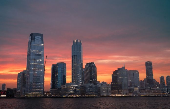 Stunning view of New York City skyline with a vibrant sunset reflecting on skyscrapers.