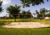 A vibrant playground with swings in a Houston park under a blue sky, perfect for family outings and leisure.
