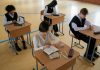 Group of diverse students studying in a well-lit indoor classroom setting.